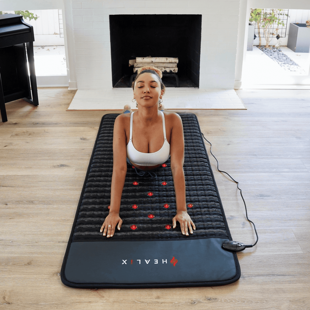 Full-length combination PEMF and infrared mat laid out on the floor by a fireplace