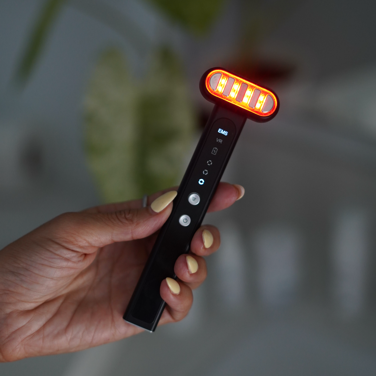 Hand holding the TheraSculpt in red light mode