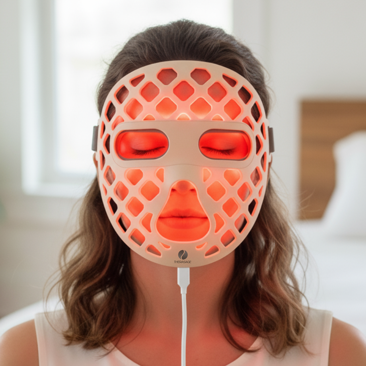 Woman wearing the TheraGlow Mask2Go+ face mask in red light mode