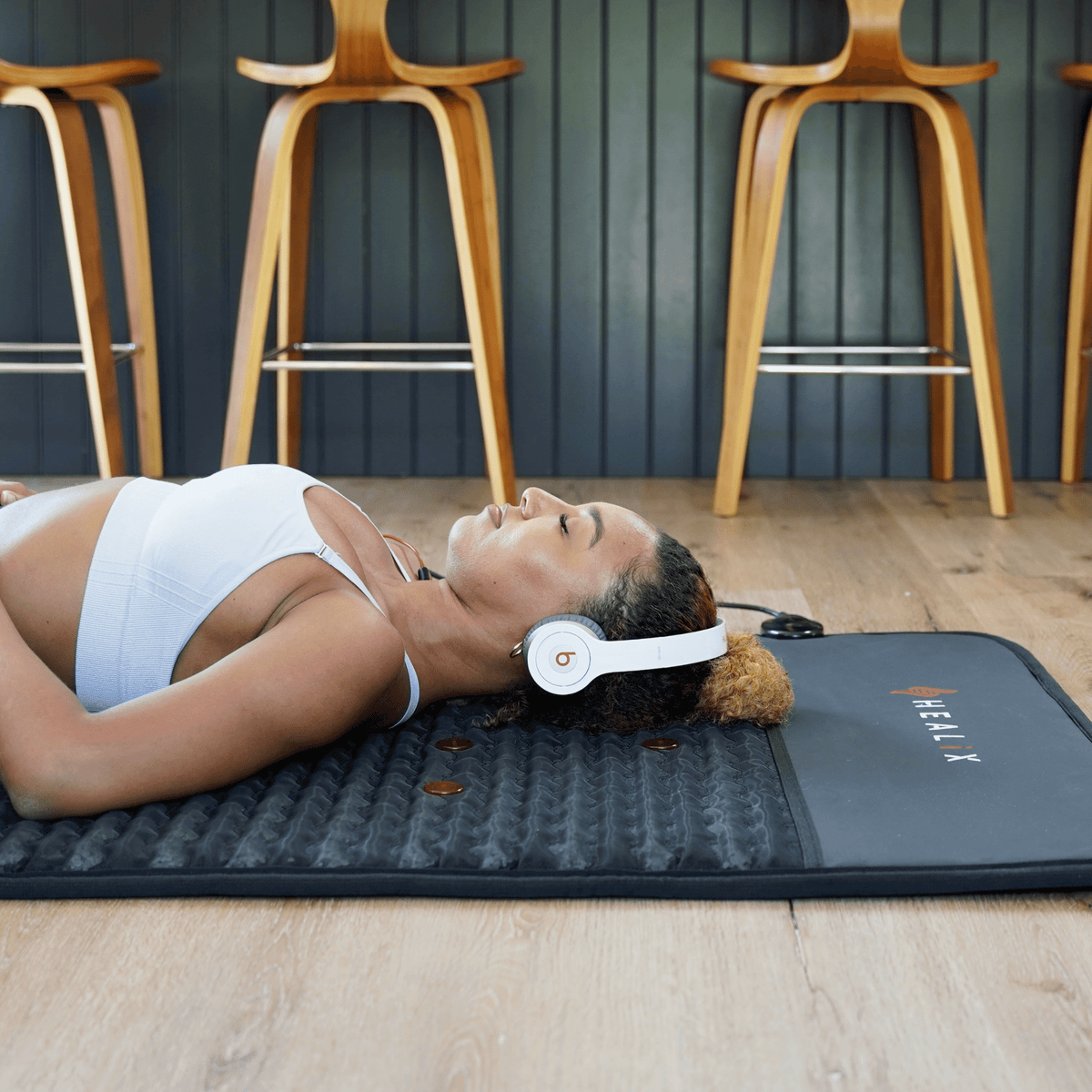 HEALiX Revive PEMF Mat on the wood floor, lying flat for a session