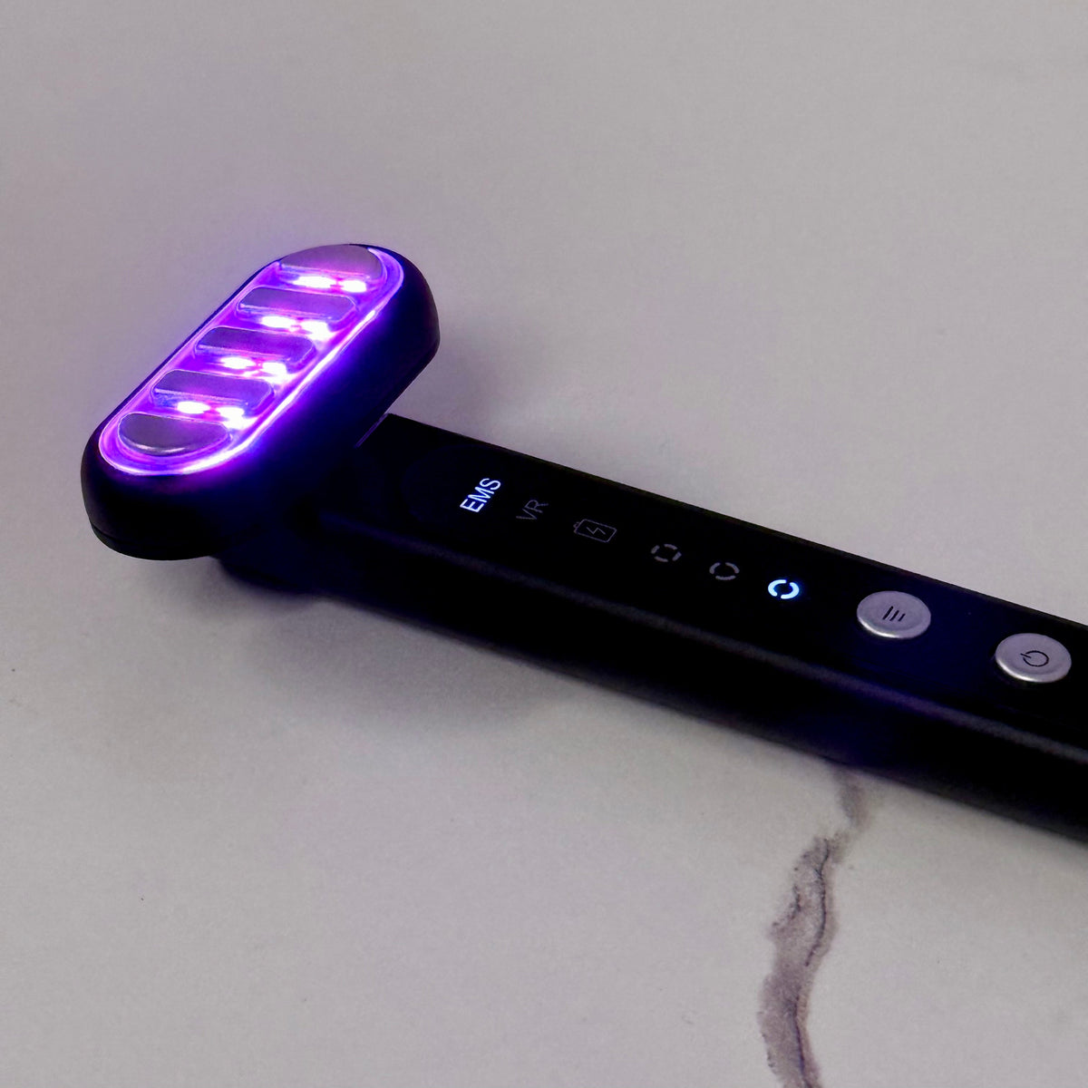 TheraSculpt massage head glowing purple, close up