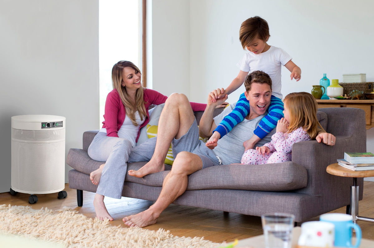 Airpura Odor-Free G600 air purifier beside a family relaxing on the sofa