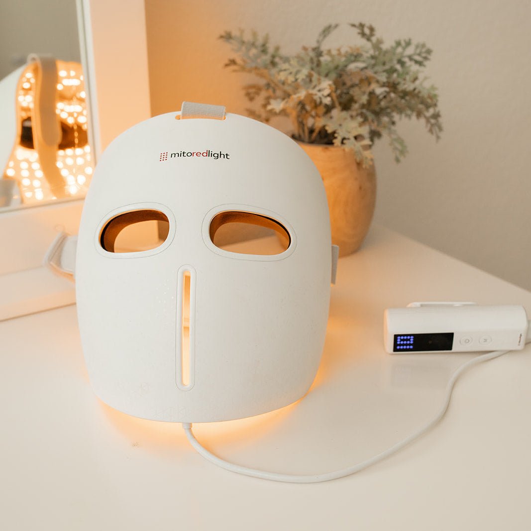 MitoGLOW mask resting on the vanity beside its controller