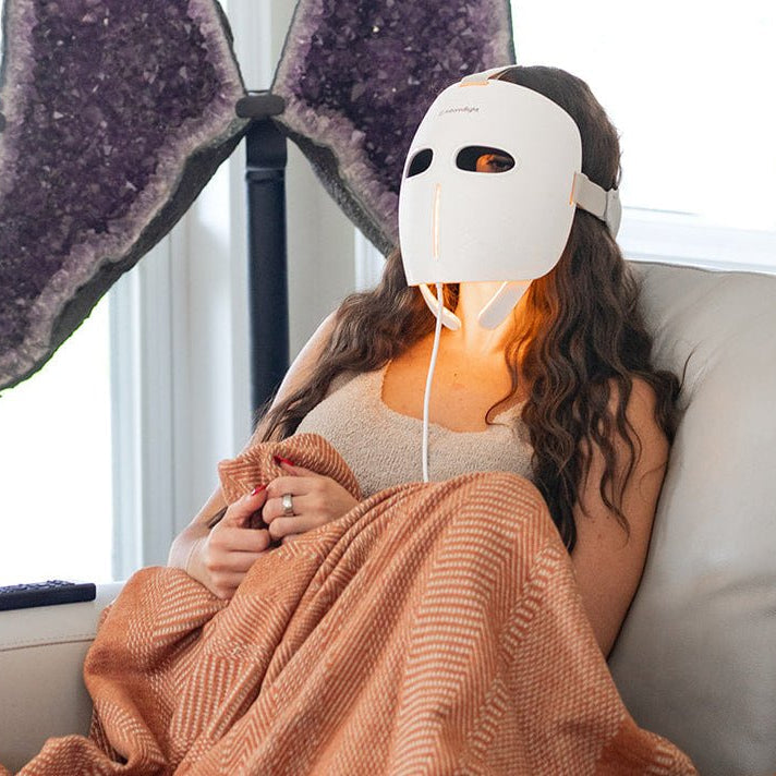 MitoGLOW mask worn while relaxing on the sofa under a blanket