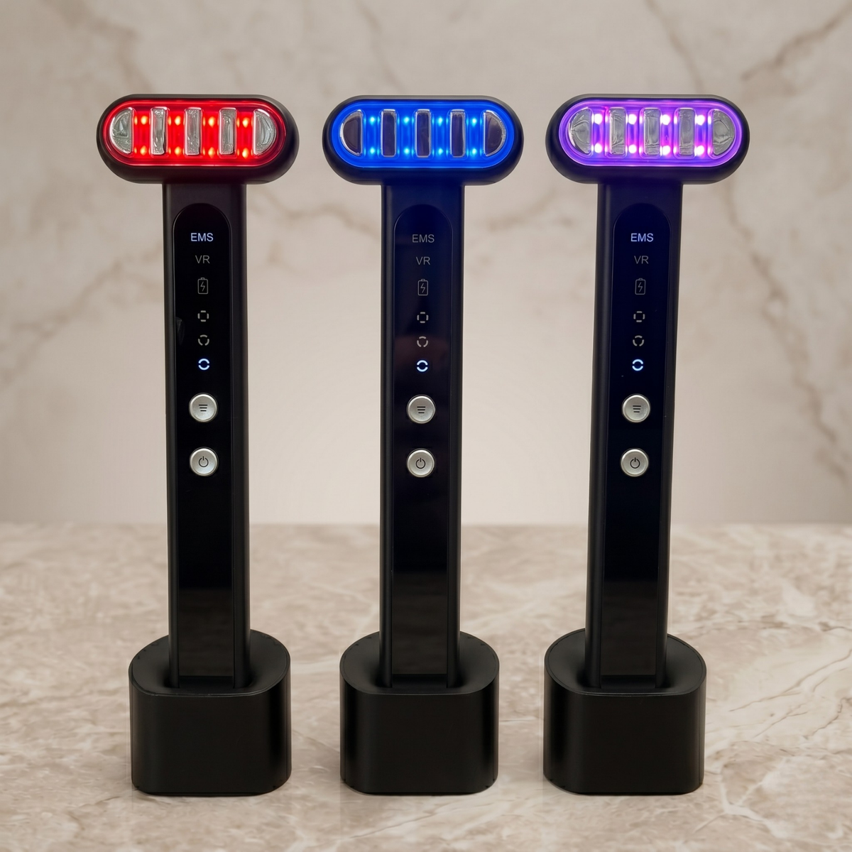 Three TheraSculpt devices in their charging stands glowing red, blue and purple