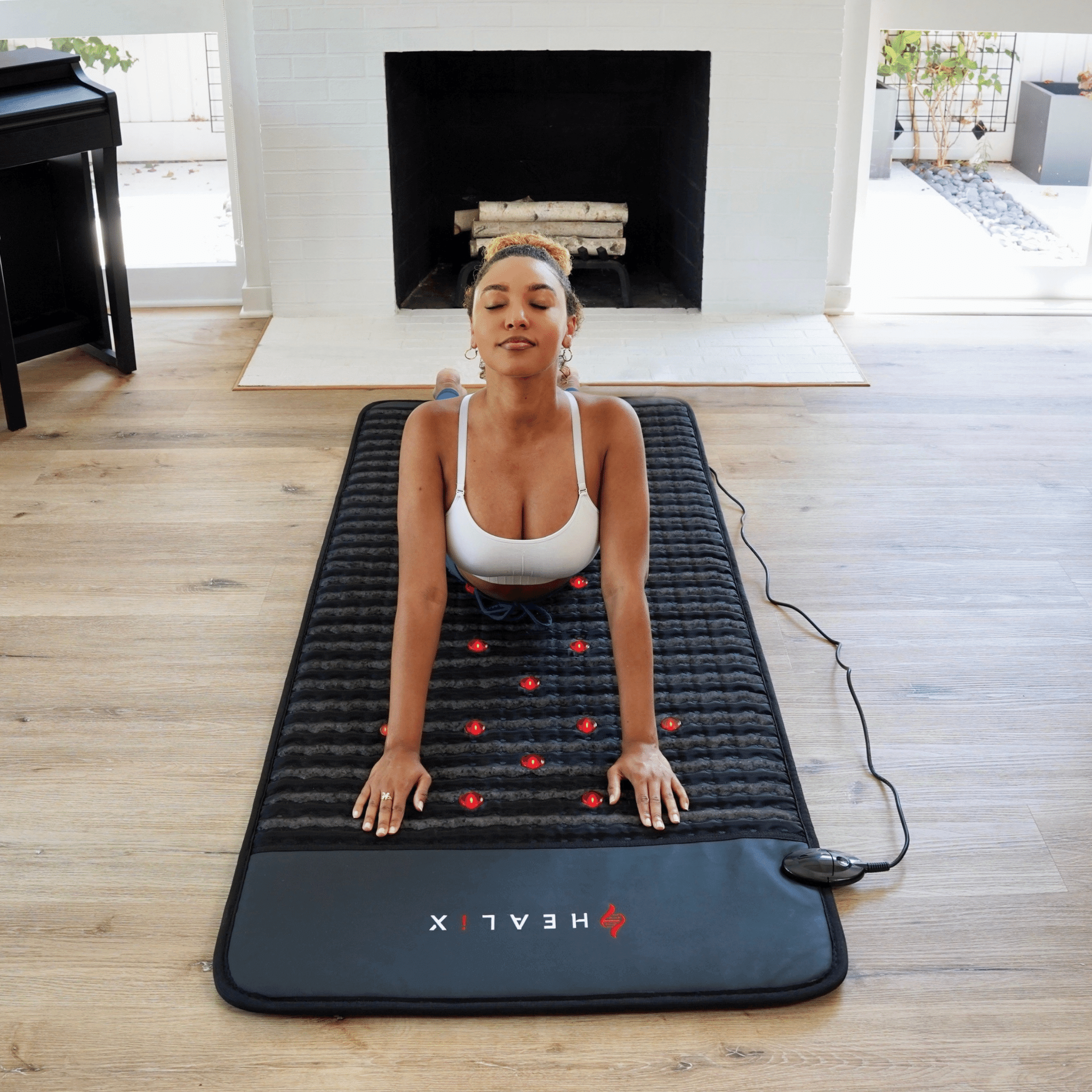 HEALiX Revive PEMF Mat full length on the floor, stretching by the fireplace