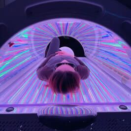 View from the foot end of the BioLight Helios System with a person under the multicolor LED canopy