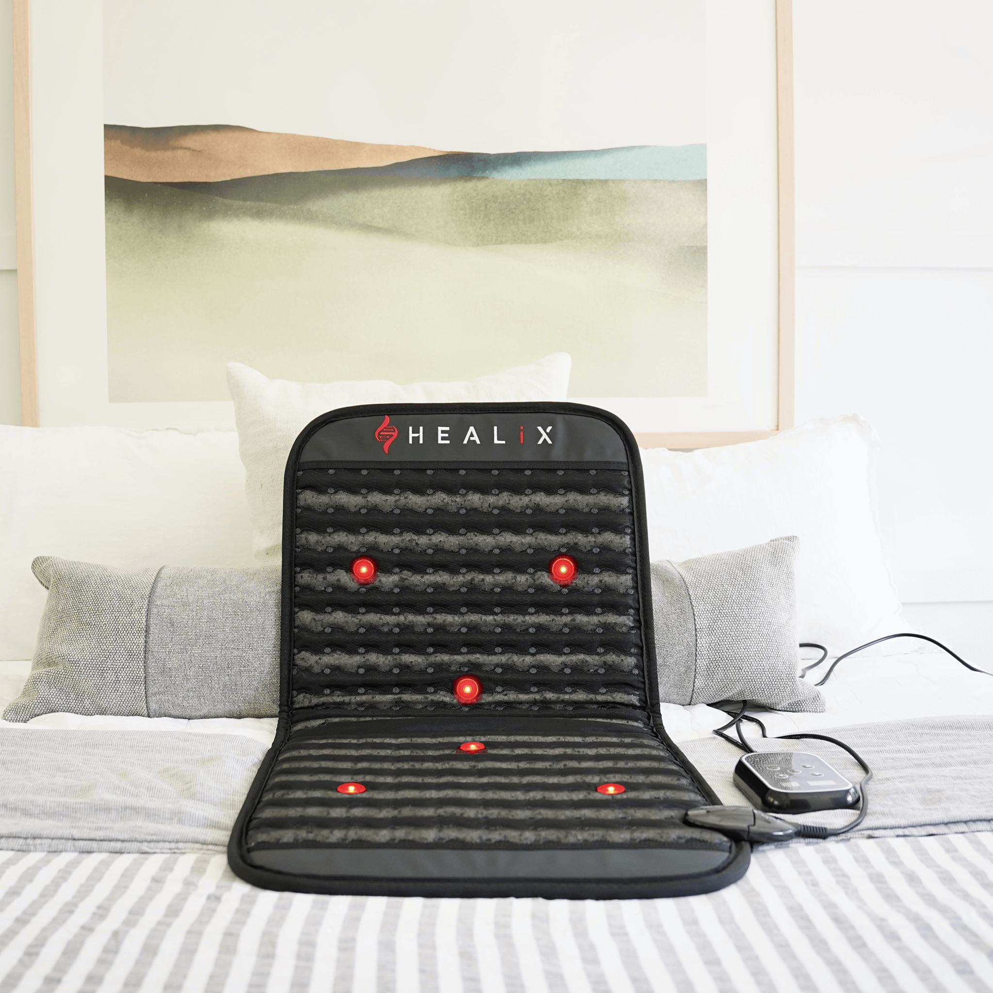HEALiX Revive Mini PEMF Mat propped upright on a bed, photon lights glowing
