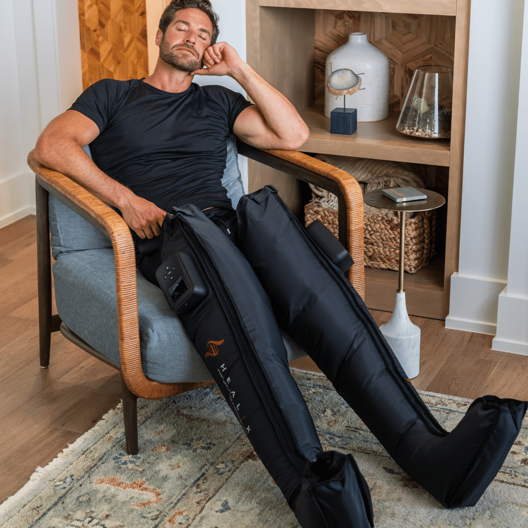 HEALiX Flow IPC Boots worn in an armchair during a compression session