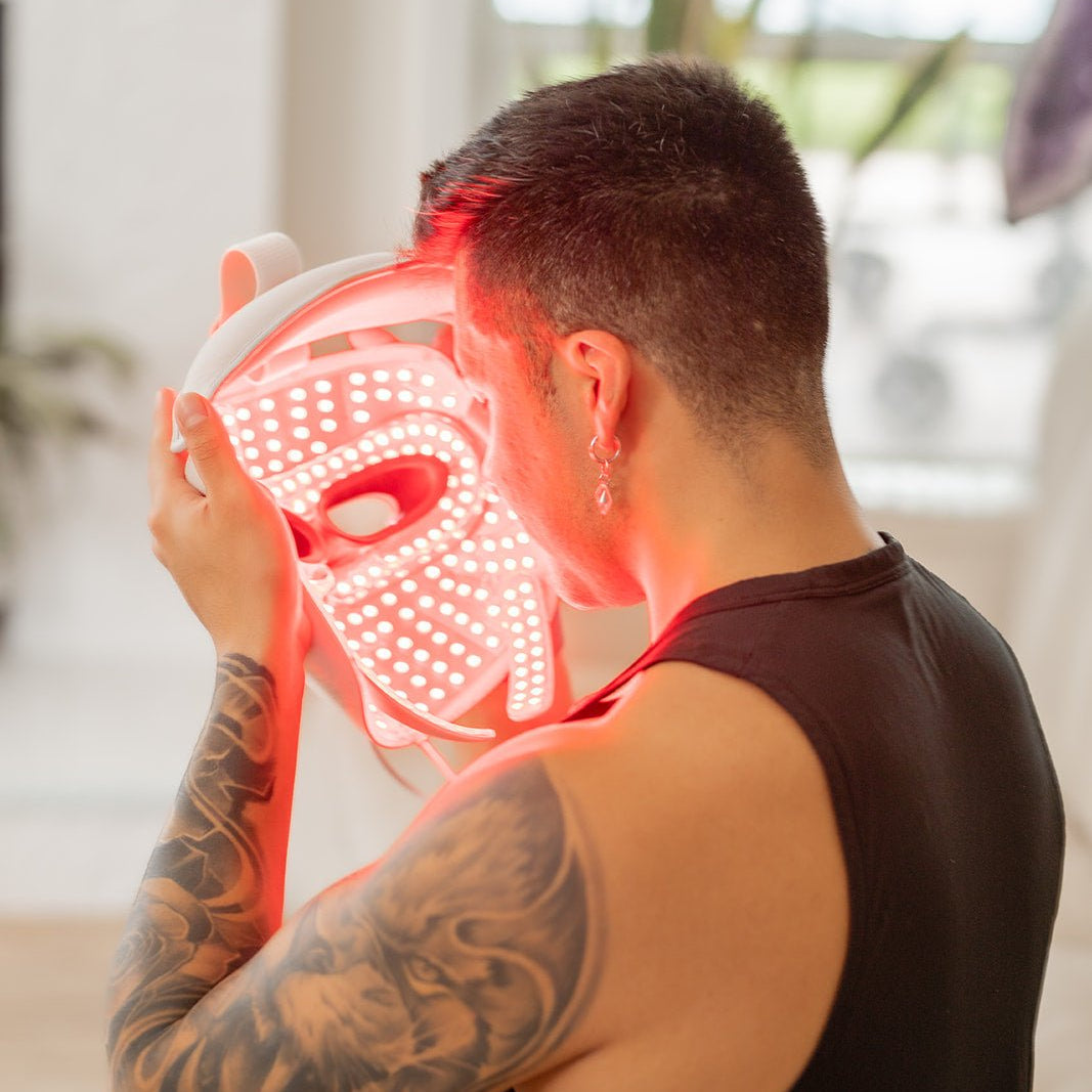 MitoGLOW mask being fitted by a man, red LEDs lit