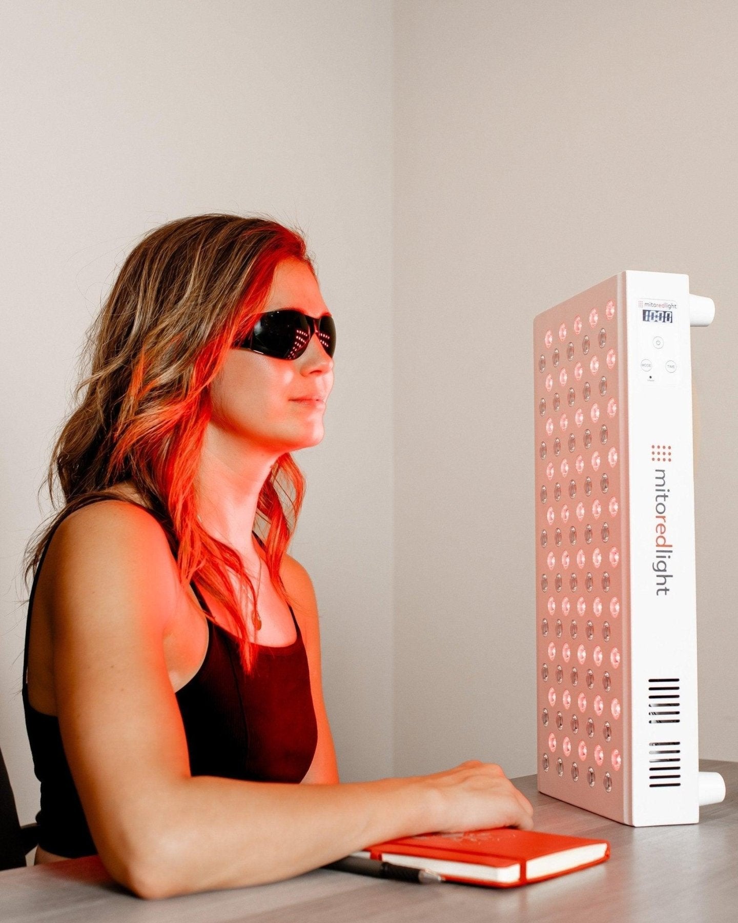 MitoMID 2.0 desk session, woman wearing eye protection by the lit panel