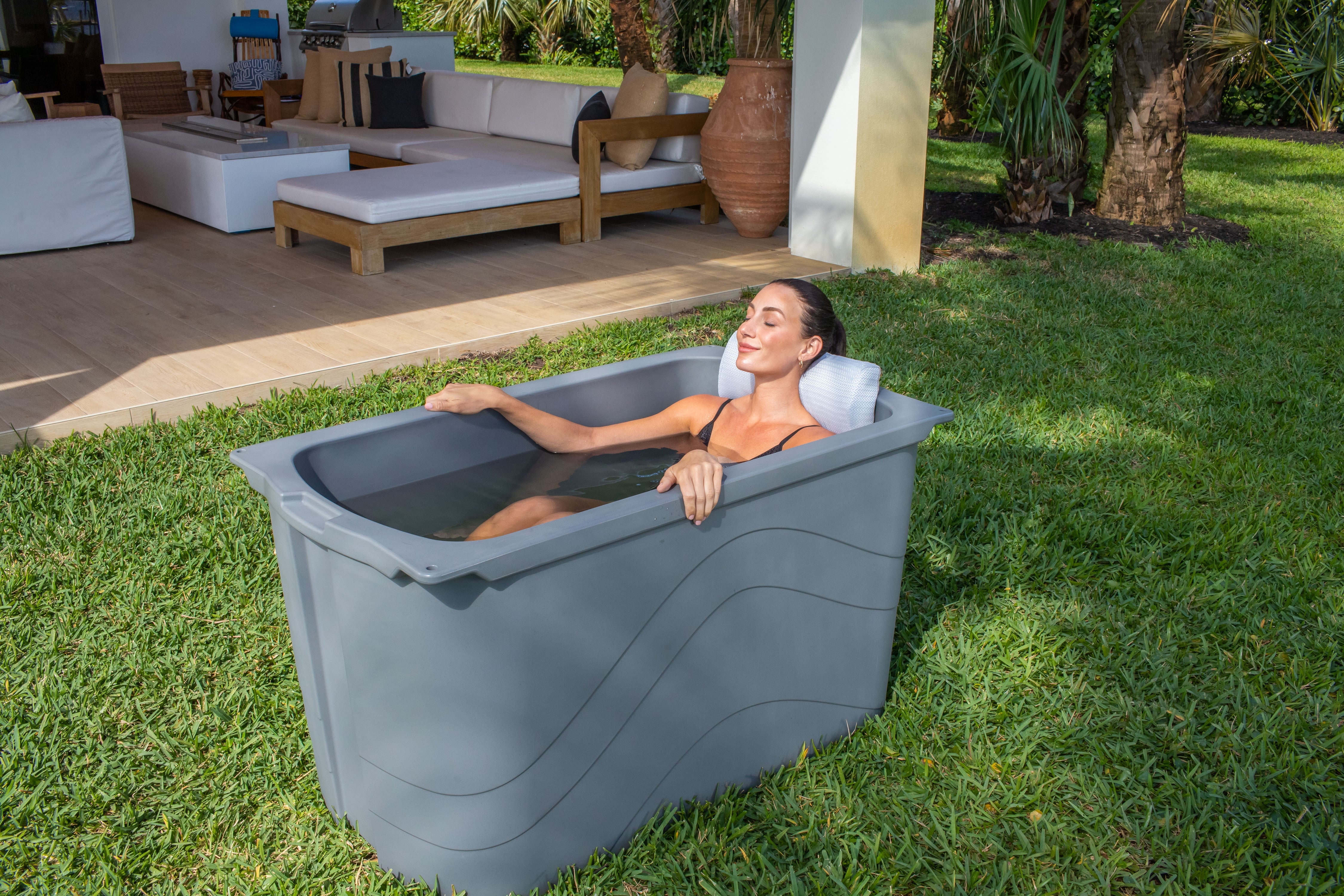 Frozin 400 grey granite cold plunge with a woman relaxing on the lawn #Color_Grey Granite